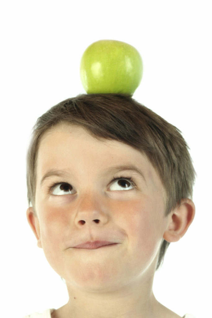Child with apple on his head.
