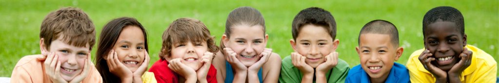 Row of smiling kids looking at the camera.