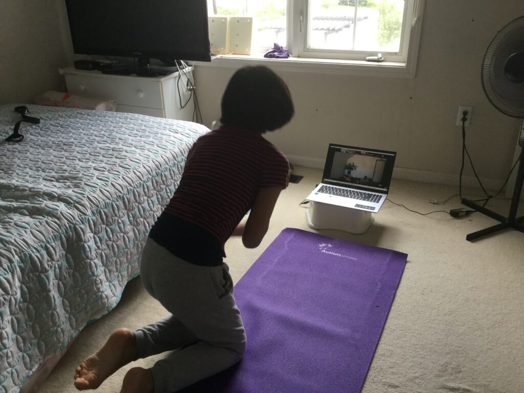 Participant doing following an online yoga routine from their bedroom floor