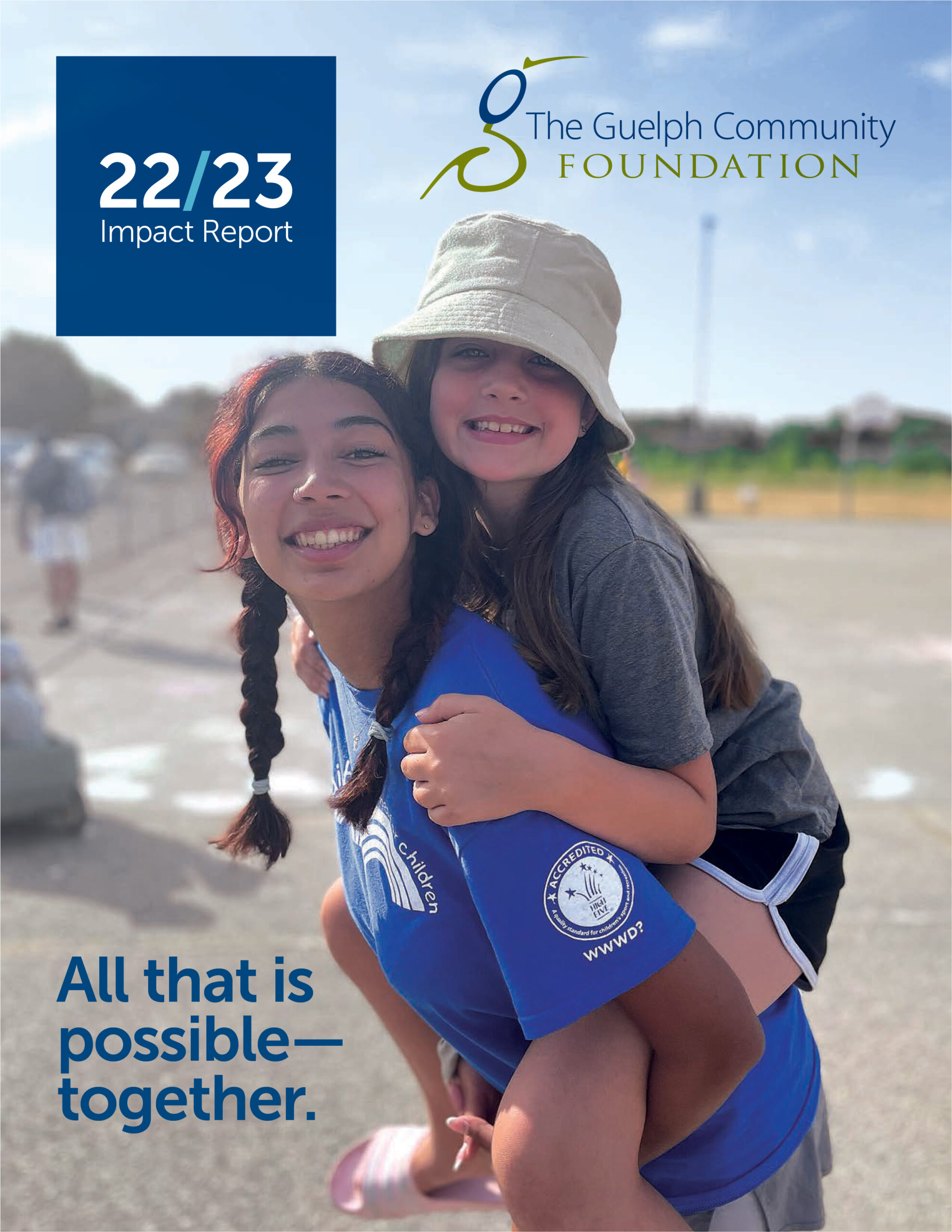 Cover Image of the 2022/23 Annual Report with subtitle All that is possible - together. Image of a teen girl with a younger girl on her back.