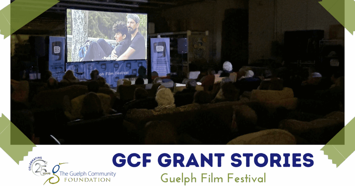 People sitting and watching a the film projector part of the Guelph Film Festival