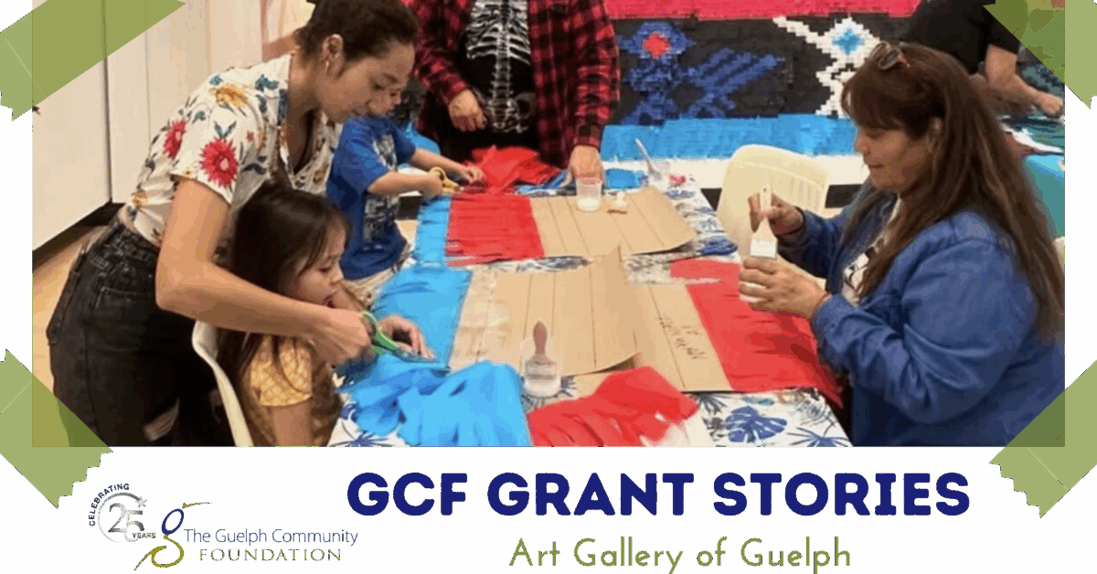 Adults and children collaborate on a colorful craft project using red and blue fabric at a community art event.
