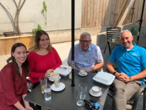 Staff photo, four people sitting at an outdoor patio
