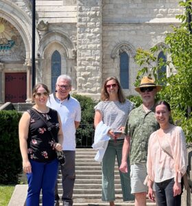 staff photo in front of the Guelph Basilica, five people outside on the church steps