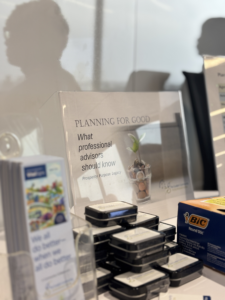 Photo of Planning For Good sign with items on desk, pen box, mint boxes and bookmarks.