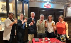 Group holding beers at Sleeman Breweries with John Sleeman in the middle