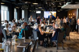 A lively restaurant scene with diverse diners engaged in conversation and enjoying meals.