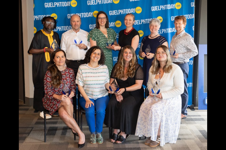 Group of eleven people posing with awards in front of a GuelphToday.com backdrop at an indoor event.
