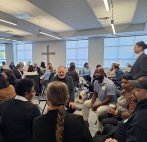 Attendees engage in conversation in small circles during a networking exercise at the Finding Abundance symposium.