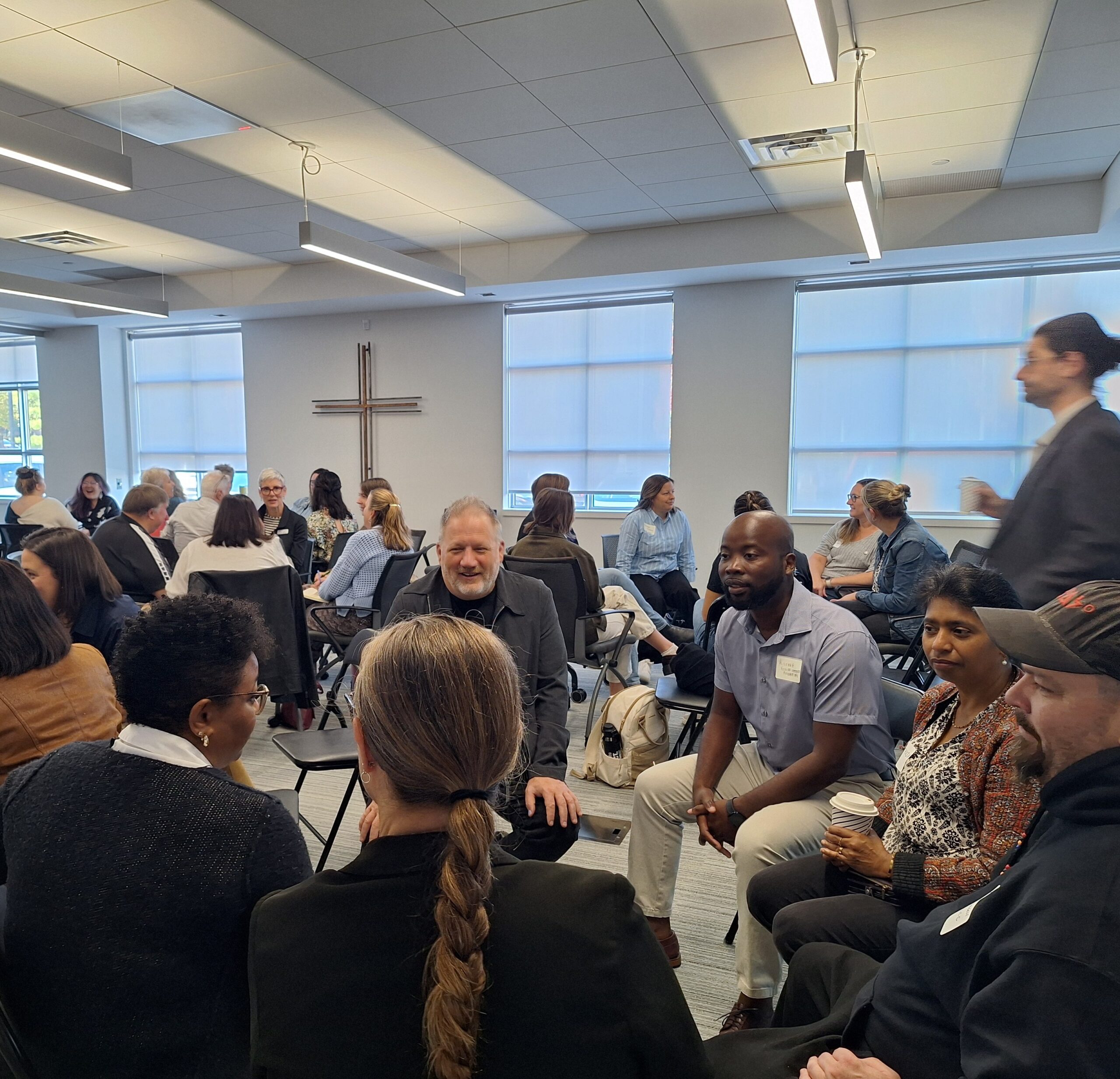 Attendees engage in conversation in small circles during a networking exercise at the Finding Abundance symposium.