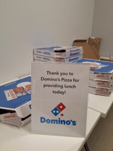 A display of Domino’s Pizza boxes and a sign thanking Domino’s Pizza for providing lunch at the Finding Abundance symposium.