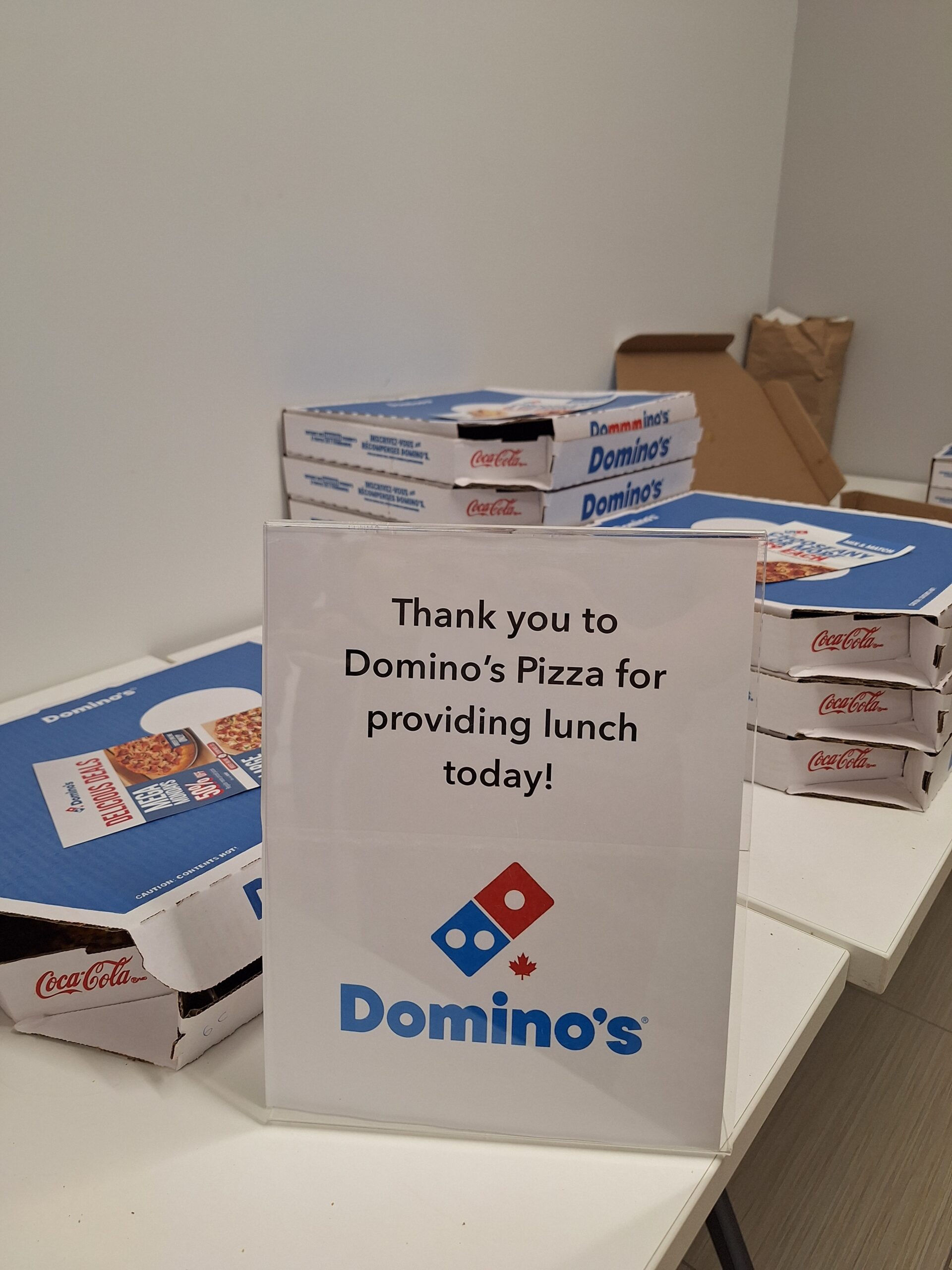 A display of Domino’s Pizza boxes and a sign thanking Domino’s Pizza for providing lunch at the Finding Abundance symposium.