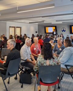 Attendees engage in conversation in small circles during a networking exercise at the Finding Abundance symposium.