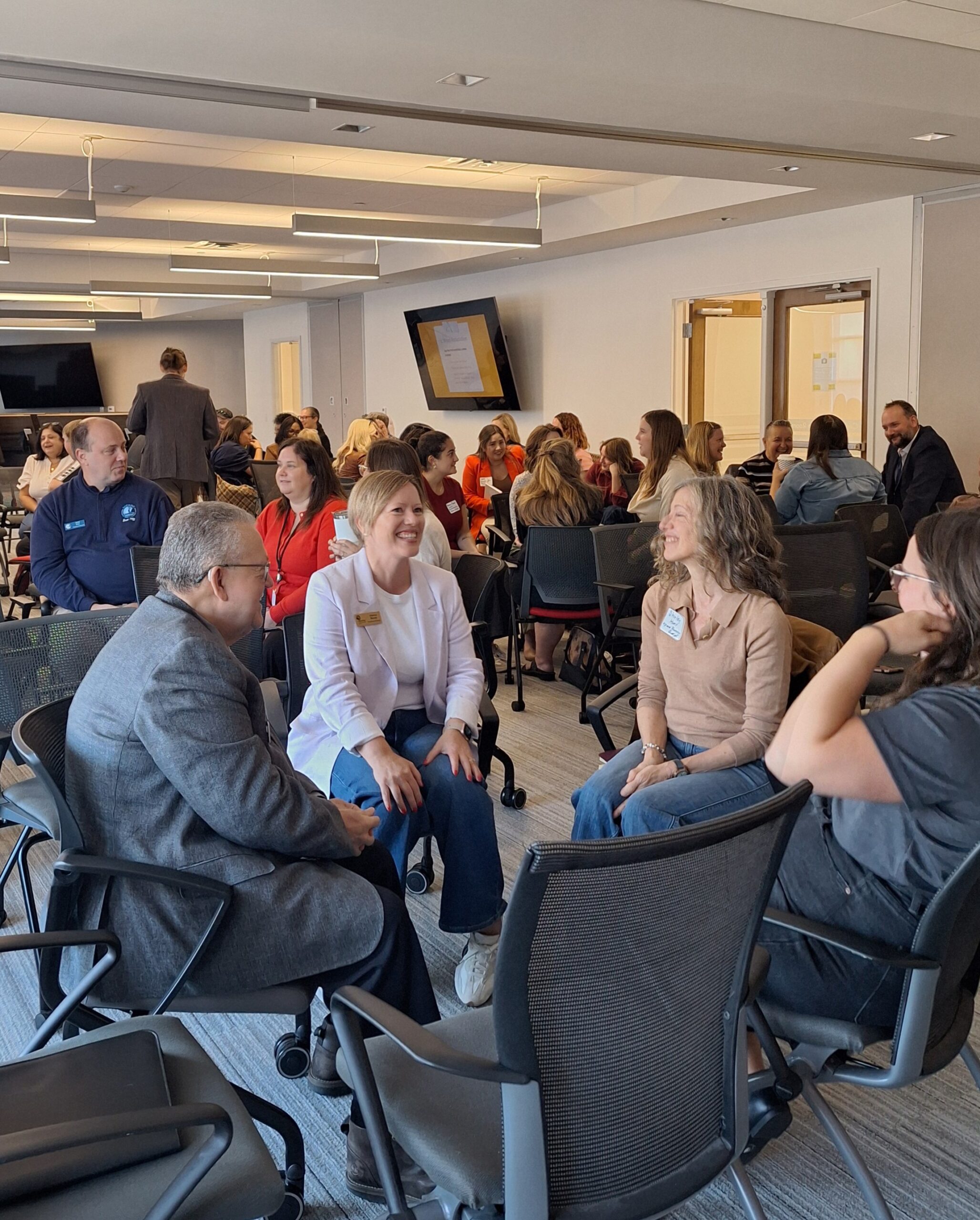 Attendees engage in conversation in small circles during a networking exercise at the Finding Abundance symposium.